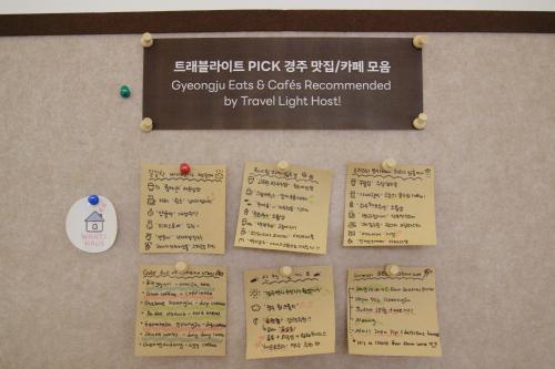 un tablón de anuncios con carteles y textos escritos en Travel Light Hostel Gyeongju, en Gyeongju