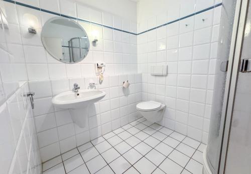 a white bathroom with a sink and a toilet at 33 - 17 Hotelkamer voor twee personen in Marx in Bunkenburg