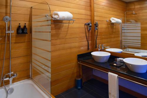 アンタナナリボにあるTANA-Boutique Hôtelの洗面台2つとシャワー付きのバスルーム