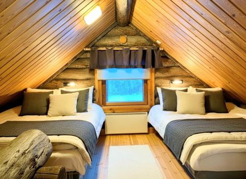 a bedroom with two beds in a log cabin at Villa Kelotupa in Hossa