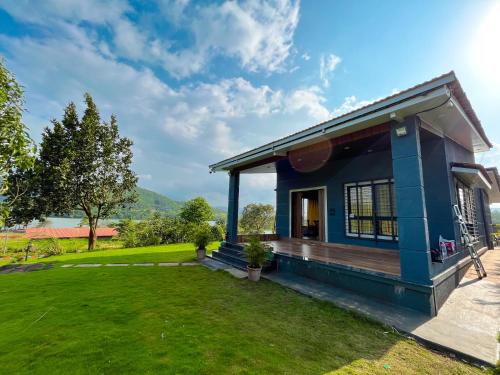 浦那Waterrock Bhor的蓝色的房子,前面有绿色草坪