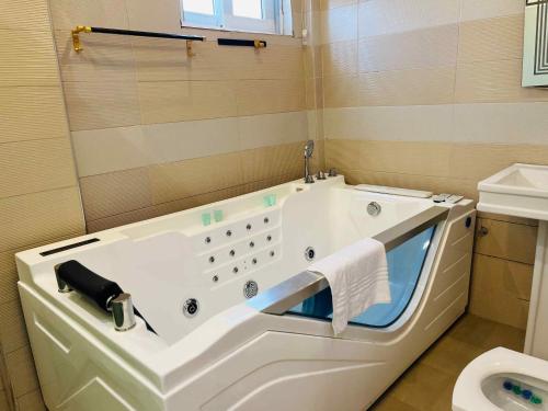 une baignoire dans une salle de bain avec toilettes dans l'établissement Sebrose Star Palace Hotel, à Hohoe