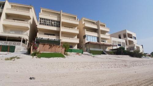 a large apartment building on the beach with a building at Zayed chalet for families in Al Khīrān