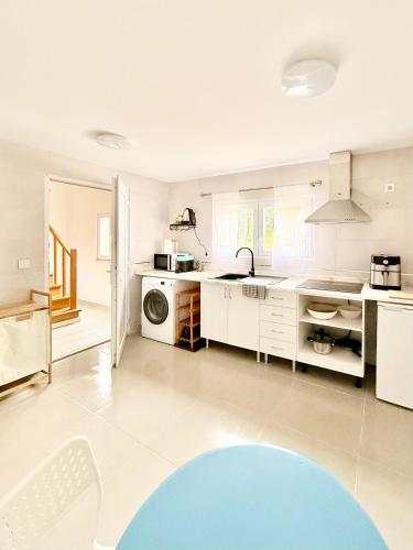 a large kitchen with white cabinets and a blue rug at Monte do Garnacho - Villa in the Mountains in Sertã