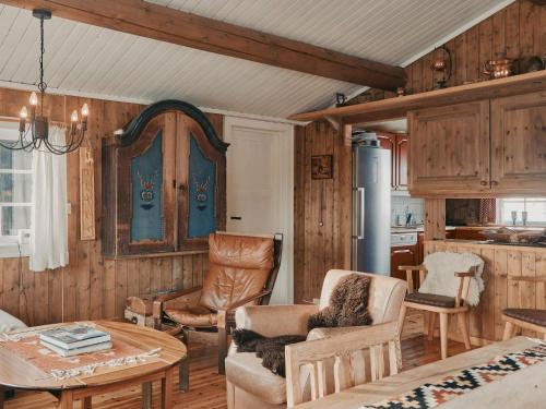 a living room with wooden walls and a table and chairs at Hytte I Uvdal Med Ski-Inout in Uvdal