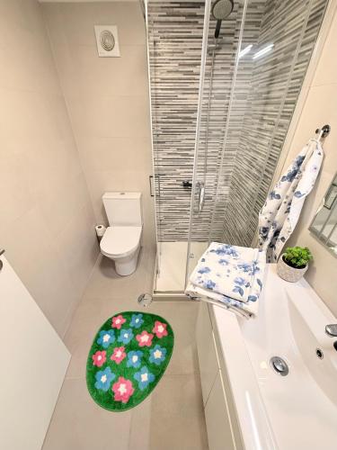 a bathroom with a toilet and a green rug at Monte do Garnacho - Villa in the Mountains in Sertã