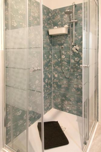 a bathroom with a shower with a glass door at MagliaNeraApartment in Quartu SantʼElena