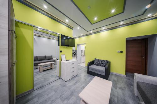 a living room with a couch and a chair at White House Apartman Miskolc, Green Room in Miskolc