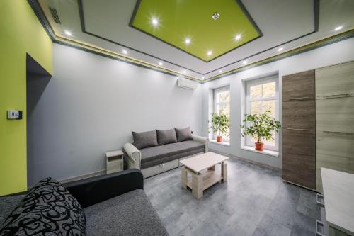 a living room with a couch and a table at White House Apartman Miskolc, Green Room in Miskolc