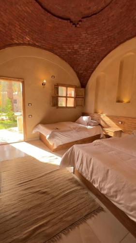 a bedroom with two beds and a window at Siwa Palace Lodge in Siwa