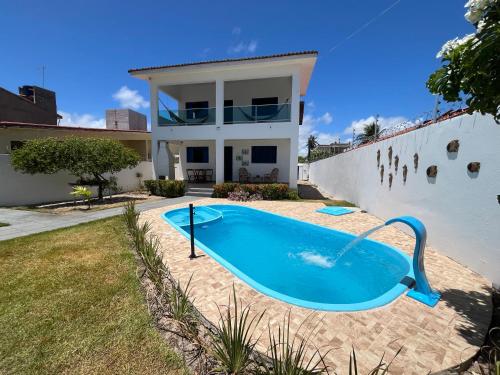ein Swimmingpool vor einem Haus in der Unterkunft Casa vista Mar, pé na areia com piscina ! in Pitimbu