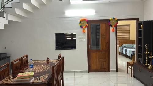 a room with a dining table and a bedroom at Prasadam Inn Varkala in Varkala