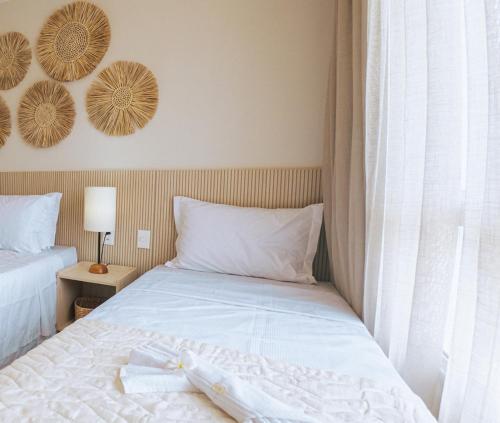 ein Schlafzimmer mit einem Bett mit weißen Laken und einem Fenster in der Unterkunft Ocean Pipa in Pipa