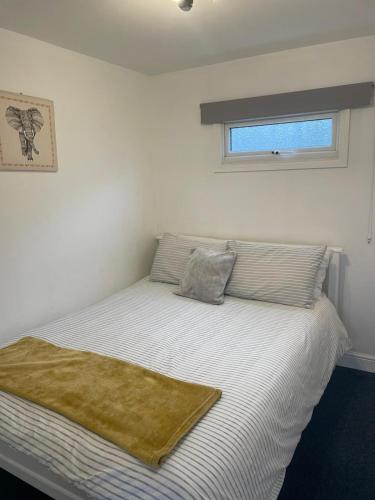 a bedroom with a bed with a blanket on it at Sandhaven Beach Chalets in South Shields