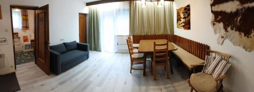 ein Wohnzimmer mit einem Tisch und einem blauen Sofa in der Unterkunft Ferienhaus Spalek in Innerkrems