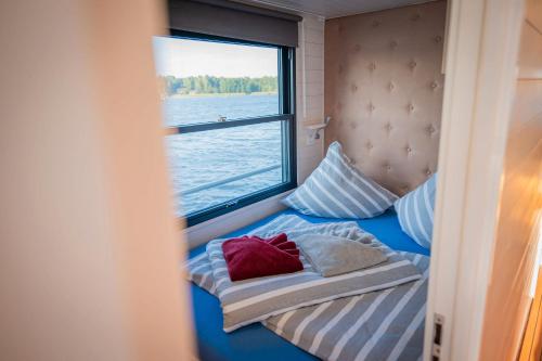 ein kleines Bett in einem Zimmer mit Fenster in der Unterkunft Adventurous Water House Emsel Woma in Fürstenberg-Havel