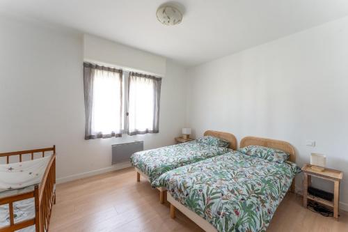 une chambre avec un lit et un bureau et deux fenêtres dans l'établissement Spacieux T3 cosy au cœur d’Hossegor, à Soorts-Hossegor