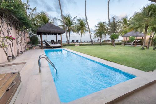 einen Pool mit Pavillon und Palmen in der Unterkunft Casa Mar: vista e acesso à praia | By Carpediem in Jacumã