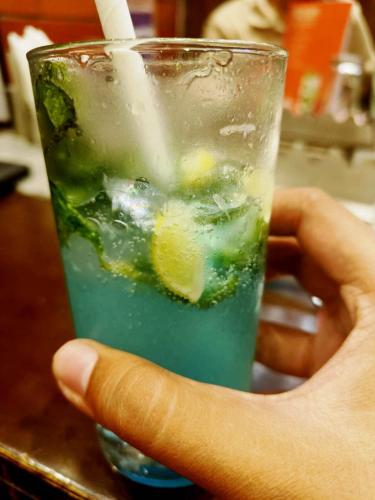 GondaSolitaire Resort的一只手拿着一杯里面放着柠檬片的饮料