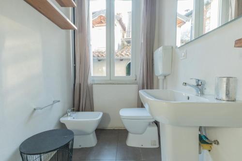 a bathroom with a sink and a toilet and a window at City Center - TinyStudio Piazza San Giacomo in Udine