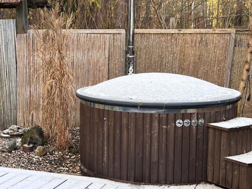ein Whirlpool in einem Garten mit Zaun in der Unterkunft Peace, Pines & Pure Air in Vangaži