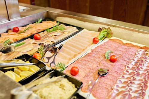 um buffet de alimentos com carnes e outros alimentos em Thermenwelt Hotel Pulverer em Bad Kleinkirchheim