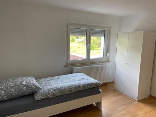 a bedroom with a bed and a window at Eigentumswohnung für 5 Personen in Donzdorf