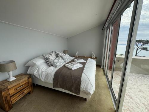 a bedroom with a bed and a large window at 5 Suikerbossie in Gordonʼs Bay
