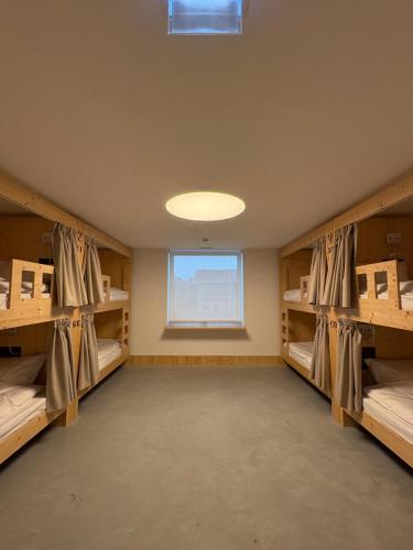 a room with wooden shelves and a window at Angeiras Beach Hostel in Lavra