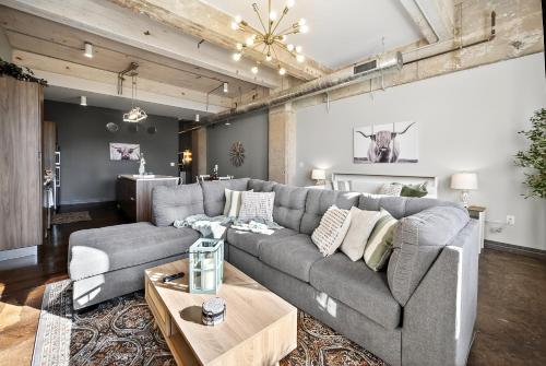 a living room with a gray couch and a table at The Magnolia - Farmhouse Loft - Sleeps 10 - Valet in Dallas
