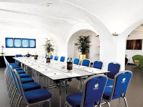 a long table and blue chairs in a room at Jet Hotel in Caselle Torinese