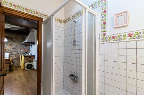 ein Bad mit einer Dusche und weißen Fliesen in der Unterkunft Casa Velarde Apto 2 in Viérnoles