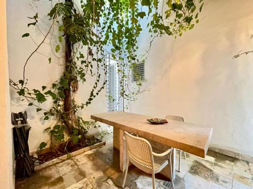 a table and chairs in a room with a tree at Suite tolila te house of medina of tunis in Tunis