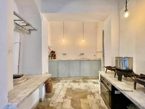 a large kitchen with white walls and a counter at Suite tolila te house of medina of tunis in Tunis
