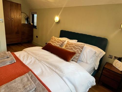 a bedroom with a bed with white sheets and pillows at Beach Retreat, Stylish 1-Bed in Canford Cliffs in Canford Cliffs