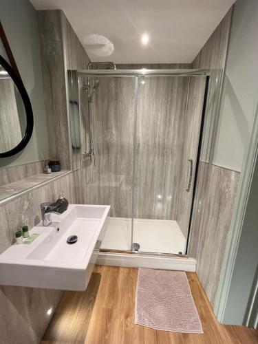 a bathroom with a shower and a sink at Beach Retreat, Stylish 1-Bed in Canford Cliffs in Canford Cliffs