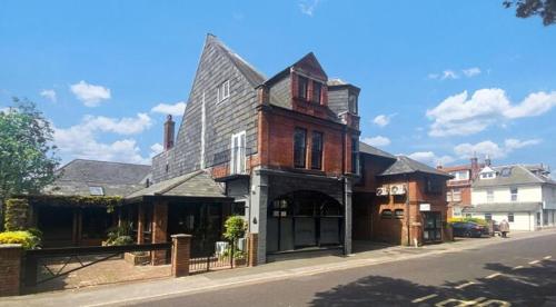 an old brick building on the side of a street at Beach Retreat, Stylish 1-Bed in Canford Cliffs in Canford Cliffs