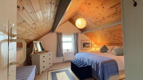 Un dormitorio con una cama con techo de madera. en The Residence Renvyle, en Gowlaun