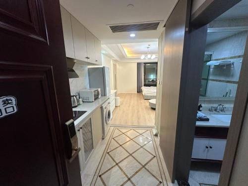 a kitchen with a door leading to a living room at Qingsu Shanghai Main Branch in Shanghai