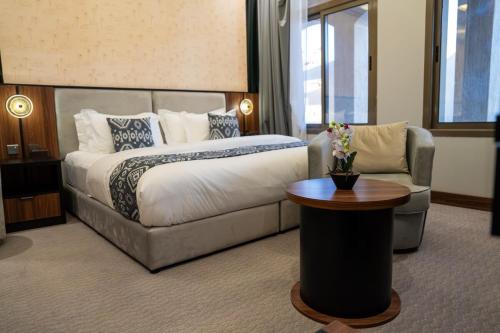 a hotel room with a bed and a chair at Jovan suites apartment in AlUla