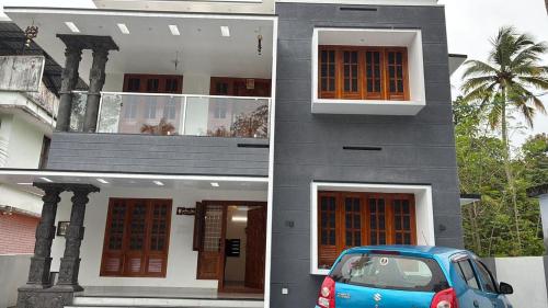 a blue car parked in front of a building at Prasadam Inn Varkala in Varkala