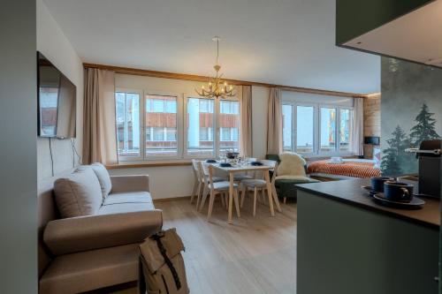 uma sala de estar com um sofá e uma mesa em 2 Design-Studios im Zentrum by Arosa Vacations em Arosa