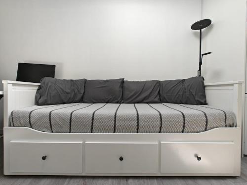 ein weißes Bett in einem Zimmer mit einer weißen Wand in der Unterkunft Skylit Studio Retreat in Norwood