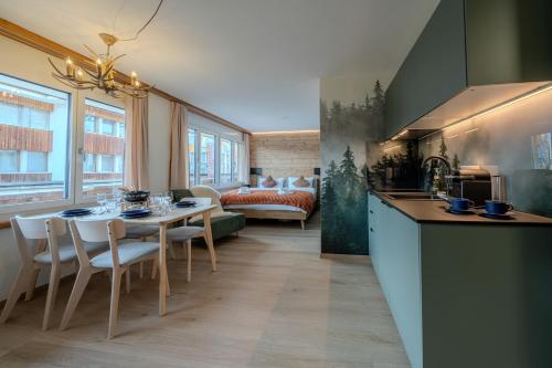 uma cozinha e sala de estar com mesa e cadeiras em 2 Design-Studios im Zentrum by Arosa Vacations em Arosa