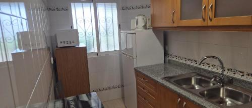 een kleine keuken met een spoelbak en een koelkast bij Apartamentos Vista Mar in Armação de Pêra