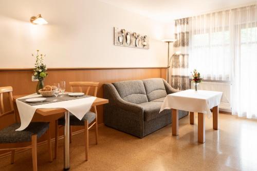 a living room with a couch and a table at App.-Haus zur Europa-Therme in Bad Füssing