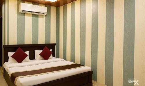 ラクナウにあるFabHotel Balajiのベッドルーム1室(赤い枕のベッド1台付)