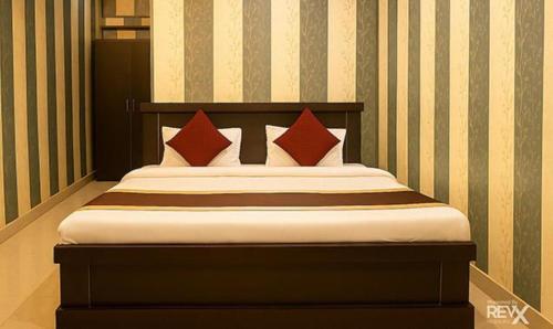 ラクナウにあるFabHotel Balajiの赤い枕が備わるベッド1台