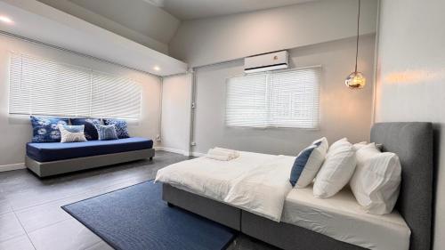 a bedroom with a bed and a blue couch at Little Escape in Bangkok