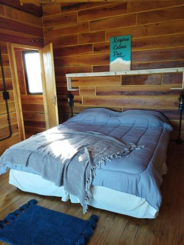 ein Schlafzimmer mit einem Bett in einer Blockhütte in der Unterkunft Casa De Mar Cielo Azul in Reta